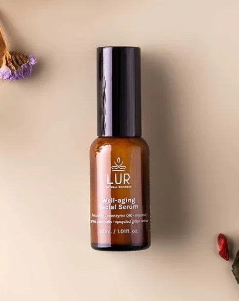 LUR well-aging facial serum in brown bottle on beige background with dried flowers, skincare product