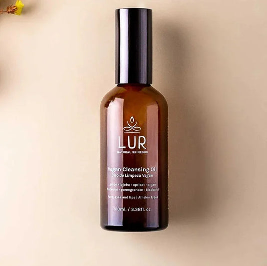 Bruine glazen fles LUR vegan reinigingsolie op een beige achtergrond, focus op huidverzorgingsproduct.