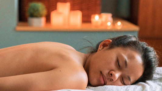 Woman relaxing during spa massage with candles in serene wellness setting